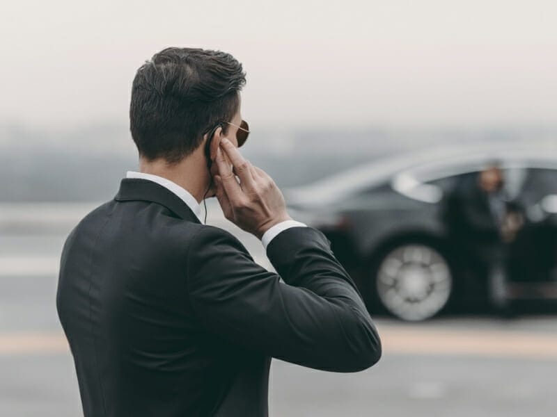 Picture of man in black suit talking on a radio to demonstrate web or cyber security activities