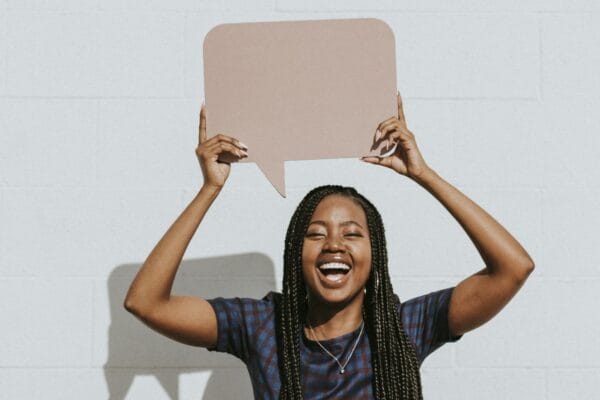 Cheerful black woman showing a blank speech bubble