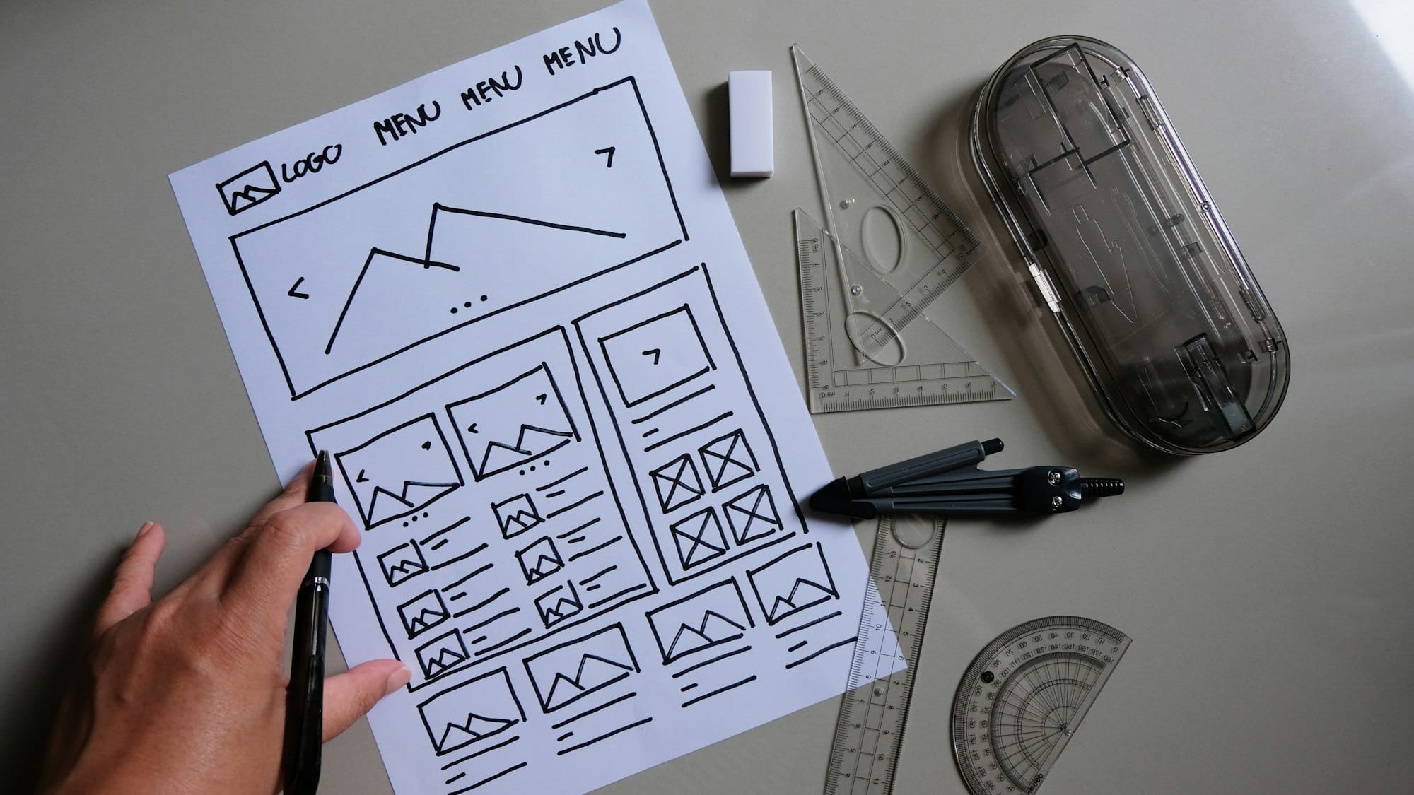 Web designer desk with website wireframe sketches and user flow.